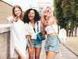 © halayalex - Three young beautiful smiling hipster female in trendy summer clothes.Sexy carefree multiracial women posing on the street background.Positive models having fun in sunglasses. They show peace sign