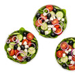 © Emil - Three vibrant bowls of fresh green salad, meticulously filled with cherry tomatoes, crisp cucumber, red onion, black olives, and feta cheese, isolated on a transparent studio background. Concept of