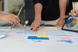 © NINENII - Businessmen team or financial data analysts working with tablets and laptop computers and data graphs together.