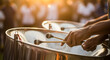 © Soulart - Close-up of a musician's hands playing steel pan drums at a vibrant outdoor festival during a golden sunset.