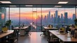 © Gao - Modern office space with desks and computers, overlooking a city skyline at sunset.