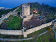 © AmazingAerialAgency - Aerial view of the imposing stone fortress, with its sturdy walls and central tower, standing guard over the landscape, Platamon, Greece.