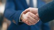 © zhang - Close-up of a professional handshake with crisp suit sleeves, conveying trust and business partnership.