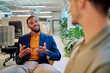 © we.bond.creations - Two businessmen engaged in a project discussion within a modern office, surrounded by vibrant green plants, fostering collaboration and innovation