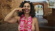 © Krakenimages.com - Middle age hispanic woman points finger to nose gesture on street in old town wearing hawaiian lei and bikini top; playful fun vacation mood.