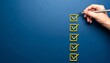 © Innovative - Hand checking all boxes on blue background, symbolizing task completion and productivity