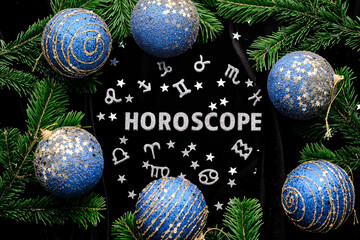 abstract background with the inscription horoscope on a black velvet background with fir branches.