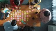 © InfiniteFlow - Top down view of smart diverse business people writing marketing idea at meeting and brainstorming start up project strategy or campaign at meeting room. Creative group discussing plan. Convocation.