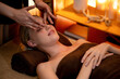© InfiniteFlow - Caucasian woman enjoying relaxing anti-stress head massage and pampering facial beauty skin recreation leisure in warm candle lighting ambient salon spa in luxury resort or hotel. Quiescent