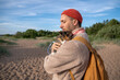 © DimaBerlin - Gentle man calms embracing nervous unhappy scowling cat on beach stroll. Concerned owner, frightened furry friend, outdoor adventure with pet at sunny shoreline, protective bond with tense pet