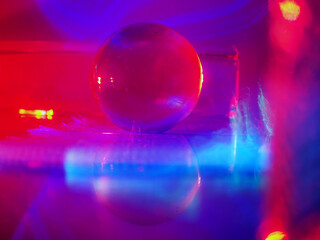 Wall Mural - a clear glass ball is sitting on a pedestal. colorful background. abstract graphic background. light