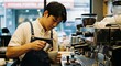 © Nazlykhan - Young asian male barista skillfully preparing coffee at a cafe espresso machine