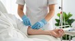 © Ura - Nurse in Blue Gloves Inserting IV Drip into Patient Arm in Hospital Setting