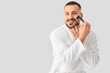 © Pixel-Shot - Young man in robe with razor on white background