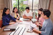 © Pichsakul - Asian business professionals discuss project strategy in modern office meeting diverse team collaborate achieving corporate goals teamwork productivity professional environment