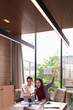 © Pichsakul - Asian Business Professionals Celebrating Financial Success Modern Office Meeting Room Reviewing Data Analytics Digital Tablet Achieving Growth Targets