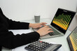 © suwanb - Close-up, Hand of  businesswoman working on laptop computer, reading financial document report charts in office.