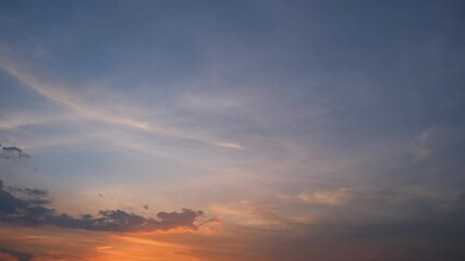 Wall Mural - A timelapse video captures a serene sunrise sky with warm orange and pink clouds gently spreading across the horizon, gradually blending into the soft blue and purple hues of early morning light.

