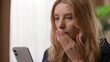 © Yuliia - Anxious disappointed Caucasian female reading negative news mobile phone bankruptcy in bedroom woman holding smartphone lady feel worried frustrated problem online money loss girl bad morning trouble