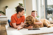 © Westend61 - Woman and child smiling and cuddling dog on living room floor