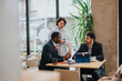 © qunica.com - Three people having a focused and engaging meeting in a stylish co working space, reflecting collaboration, teamwork, and productive discussions.