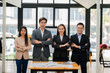 © ArLawKa - Group of Asian business people standing smiling in front of camera and crossing arms on background inside office building success concept