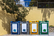 © Mike Orlov - Colorful recycling bins and labeled trash containers placed on the street. Waste separation bins used for eco-friendly garbage disposal