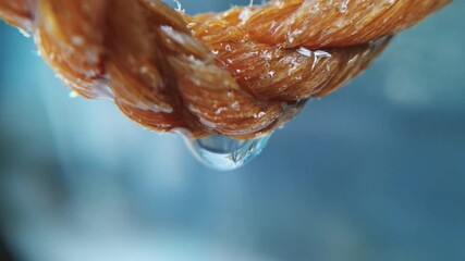 Macro footage of water dripping on a rope with a natural fall
