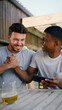 © Monkey Business - Two Male Friends Outdoors At Home Watching Sports Action On Mobile Phone