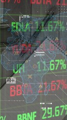 Poster - animation of stock market data processing over world map against office equipment on wooden surface