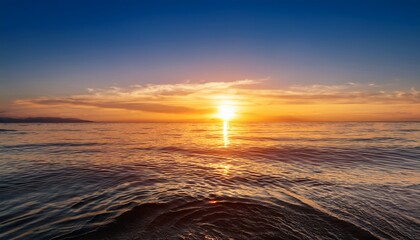 Wall Mural - a vibrant sunset over a tranquil water surface reflecting warm golden hues and gentle waves