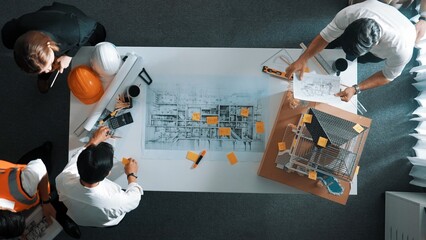 Poster - Top down view of skilled engineer team talking about house construction. Aerial view of group of architect or designer discussing and writing sticky note to brainstorm about blueprint. Alimentation.