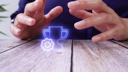 Poster - hands of a person protecting a luminous icon of a trophy with a gear on a table