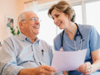 © Юлия Коротеева - Elderly man smiling while talking with nurse in healthcare setting