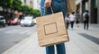© gs2 - Woman carrying a brown paper shopping bag on a city street.