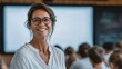 © Thananchakorn.A - Confident middle-aged woman smiling in front of an audience during a presentation or workshop in a modern conference room
