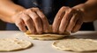 © Zahra - Close-up of hands pressing uncooked tortillas, dusted with flour on a white surface, concept for homemade food, traditional cooking and culinary arts preparation