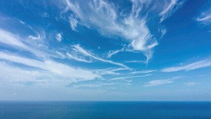 Wall Mural - Clear blue sky over a summer sea with fluffy white clouds