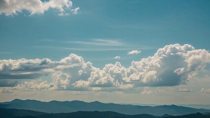 Wall Mural - Wide panoramic image featuring mountain outlines with clouds hanging in a bright sky
