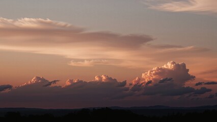 Wall Mural - Enchanting sunset backdrop with fluffy clouds and warm pastel tones