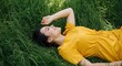 © Sifat13214 - Young woman lying in green grass, enjoying a sunny day outdoors