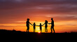 © adebaguspr - Family Silhouetted Against a Vibrant Sunset Sky Holding Hands and Enjoying Time Together.