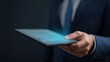 © WS Studio 1985 - Digitized Agreement: A businessman in a navy suit holds a digital tablet, illuminating the screen with the glow of an e-signature, representing innovation and technology