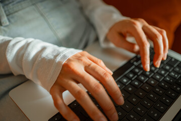 female hands typing on laptop keyboard, working remotely from home office, coding and developing pro