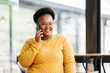 © David - african american woman entrepreneur busy with her work in the office. african american woman work on desk laptop phone while planning sales, research or financial strategy in company