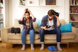© innovative world - two young people are holding their heads and in front of them there is an empty wallet and small dinars on the table in the living room, the scene shows that they have run out of money after their vac