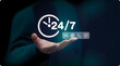 © Afsana - Service symbol in hand: A symbol of around-the-clock support and communication, with clock icon, 24/7 text and various contact methods floating above a person's outstretched hand.