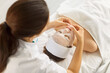 © Studio Romantic - Facial spa treatment with sheet mask, spa skincare procedure for skin of woman by cosmetologist. Top view of professional beauticians hands touch and care face skin of client. Cosmetology concept