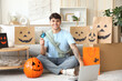 © Pixel-Shot - Young man with credit card and laptop shopping online for Halloween at home