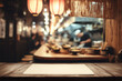 © foto Art - Empty wooden tabletop with blank paper sheet in cozy Japanese izakaya setting, warm lantern lighting and blurred chefs in background, ideal for traditional restaurant mockup or menu concept